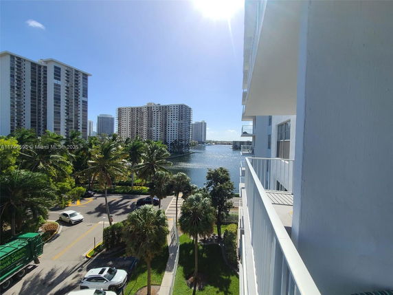 View from a building showing nearby high-rise buildings and a body of water.