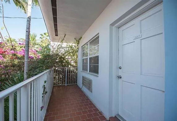 Outdoor corridor of a building with a door and window on one side.