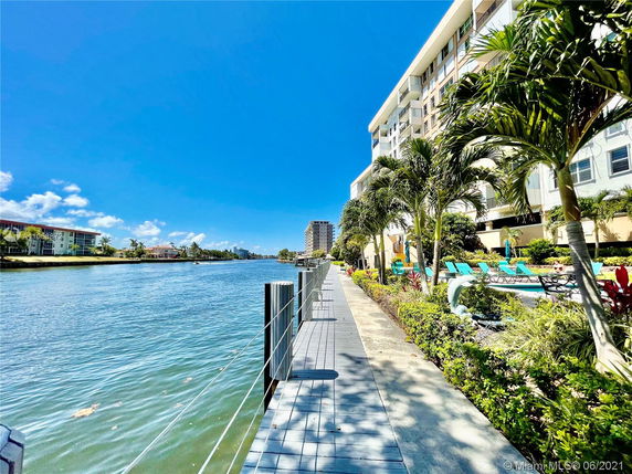 View of a waterfront area with buildings and a walkway next to a body of water.