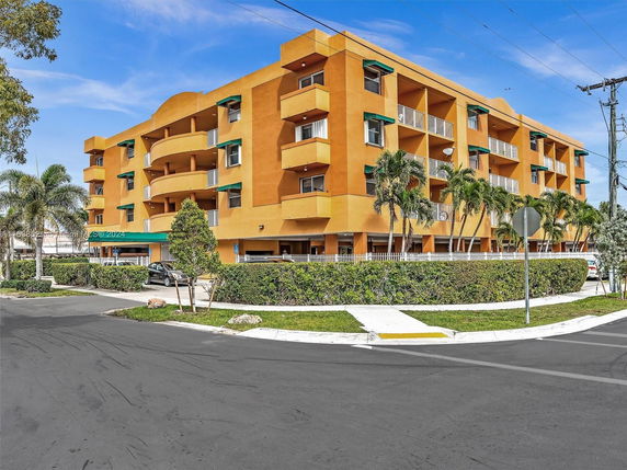 Front view of a multi-story building with orange exterior and balconies.