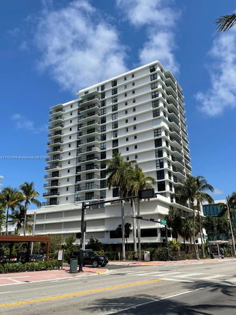 Front view of a multi-story residential building with multiple balconies.
