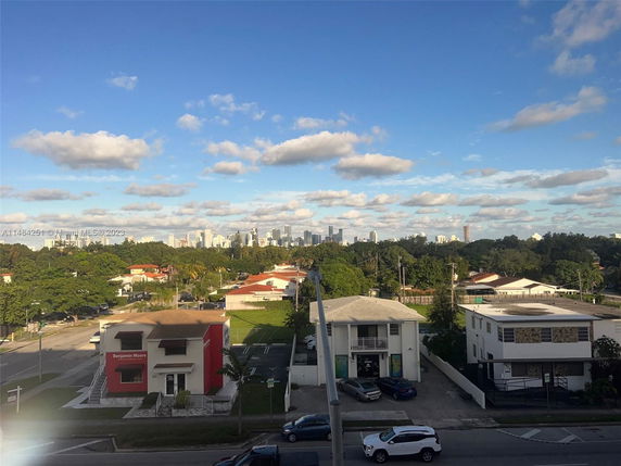 Panoramic view of urban residential and city skyline under a blue sky with clouds.
