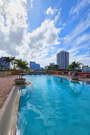 Outdoor swimming pool with city buildings in the background.