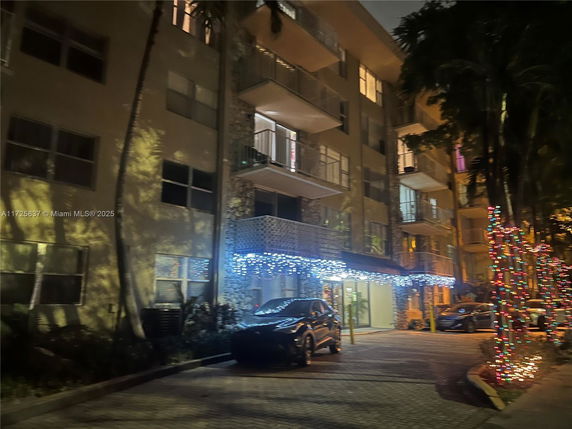Front view of a multi-story residential building with holiday lights.