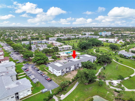 Aerial view of a residential area with multiple buildings and surrounding greenery.