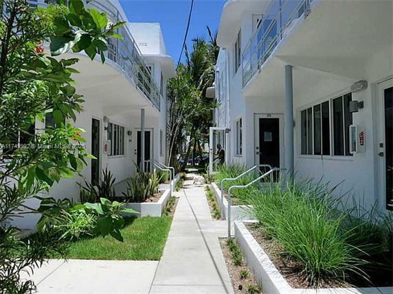 Front view of two adjacent buildings with pathways and greenery.