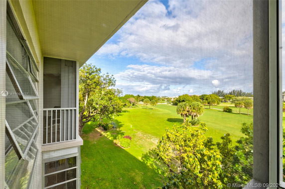 View from a building looking out onto a green landscape with trees and open grass areas.