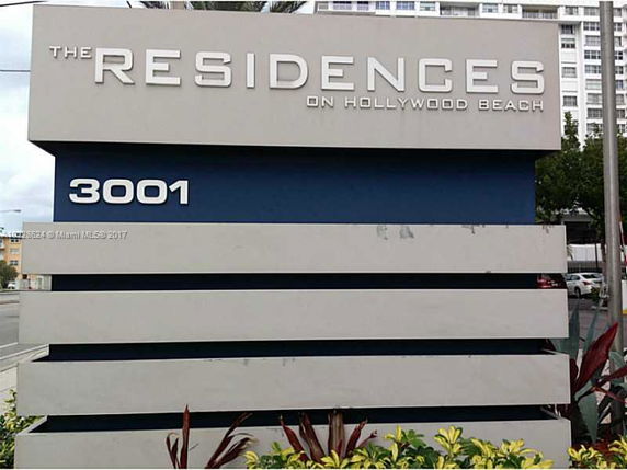 Front view of a residential building's sign with the name and address.