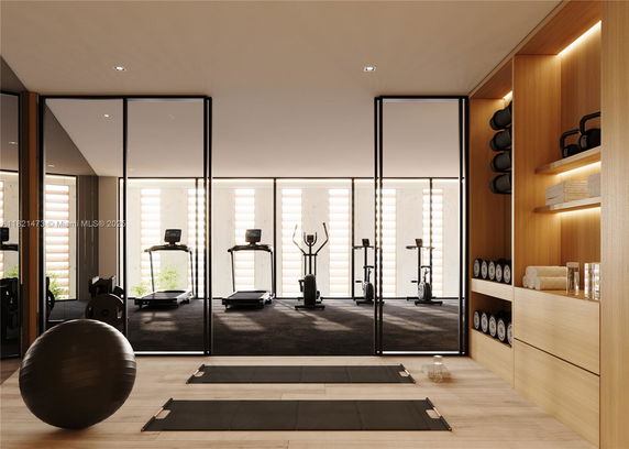 Interior view of a modern gym area with exercise equipment and storage shelves.