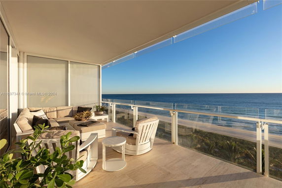 Balcony with seating area overlooking the ocean.