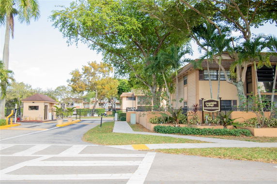 View of residential buildings with a gated entrance and sign.