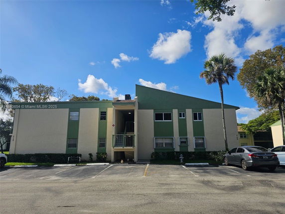 Front view of a two-story residential building with green and beige exterior.