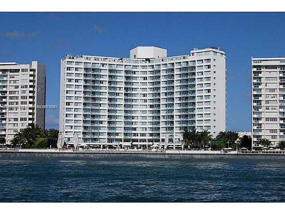 Front view of a multi-story apartment building by the water.