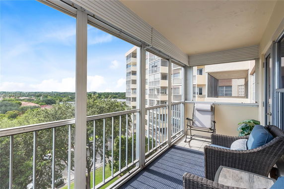 Balcony view from a high-rise apartment with surrounding buildings and greenery.
