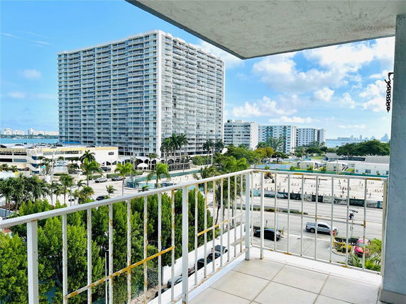 Panoramic view from a balcony showing a high-rise building and surrounding area.