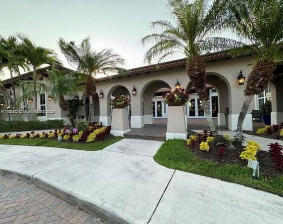 Front view of a building with arches and palm trees.