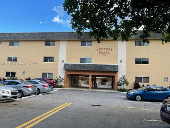 Front view of a three-story building with parking area.