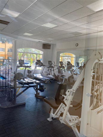 Indoor gym with various exercise equipment including treadmills and weight machines.