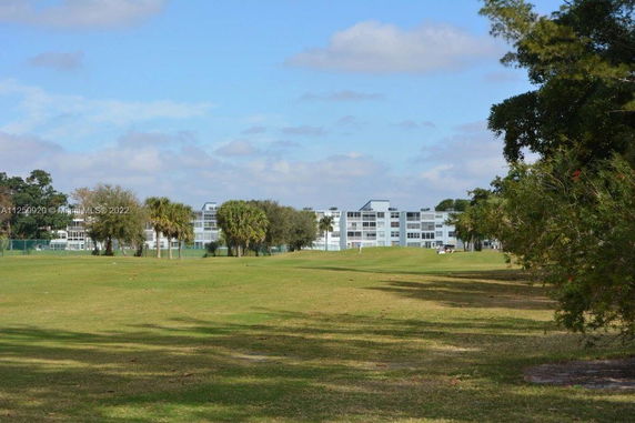Distant view of multi-story residential buildings surrounded by grassy open space.