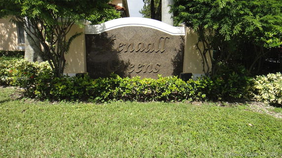 Signage of a property named Kendall Greens surrounded by greenery.