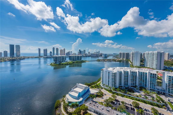 Aerial view of a coastal cityscape with high-rise buildings and a body of water.