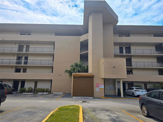 Front view of a multi-story apartment building with balconies.