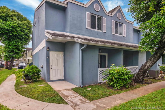 Front view of a two-story house with blue exterior and a small covered entrance.