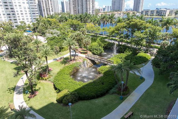 A landscaped garden area with fountains and pathways surrounded by high-rise buildings.