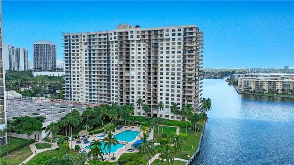 High-rise residential building with a swimming pool in a waterfront area.