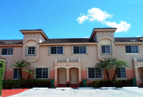 Front view of a two-story townhouse with multiple windows and decorative trims.