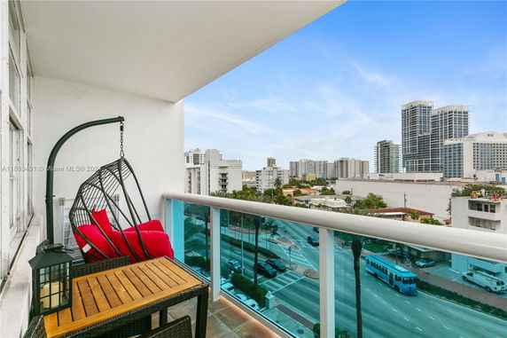 Balcony view overlooking a cityscape with high-rise buildings and street below.