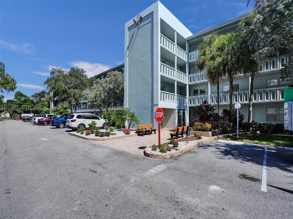 Front view of a multi-story building with parking area.