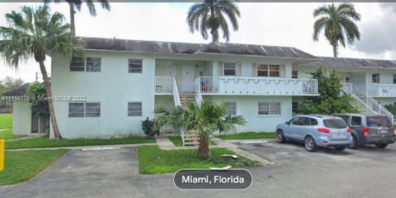 Front view of a two-story apartment building with parking spaces.