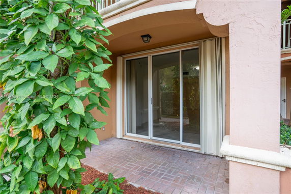 Exterior view of a building with a sliding glass door and a small patio area.