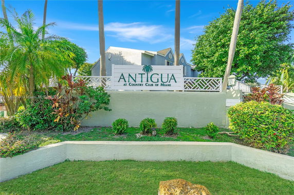 Front view of a building with a sign for Antigua at Country Club of Miami.