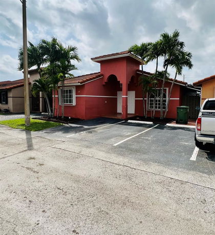 Front view of a single-story house with a red exterior and tiled roof.