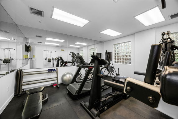 Indoor gym with various exercise equipment including treadmills and weights.