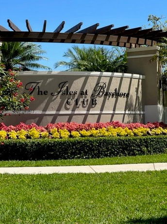 Entrance sign of a club with decorative landscaping.