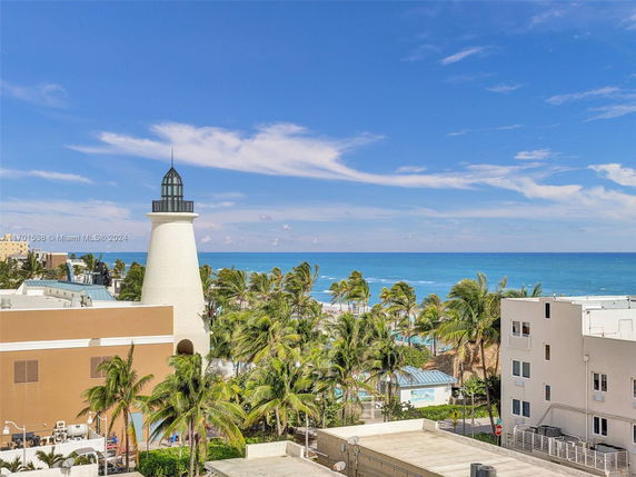 View of a coastal area with a lighthouse and nearby buildings, overlooking the ocean.