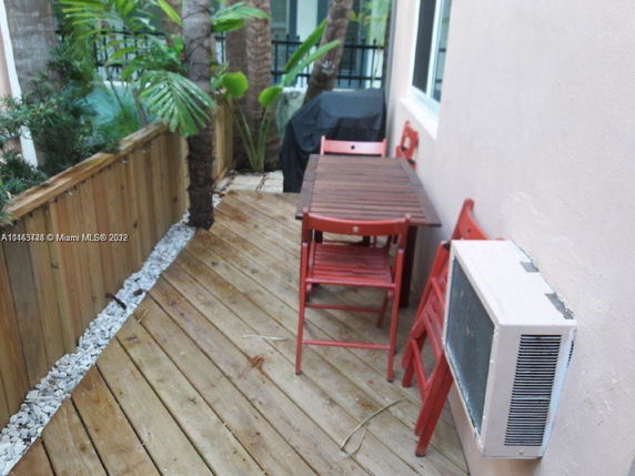 Small outdoor wooden deck area with a table and chairs.