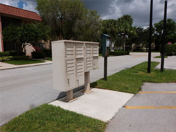 Outdoor view of mailbox units on a sidewalk in a residential area.