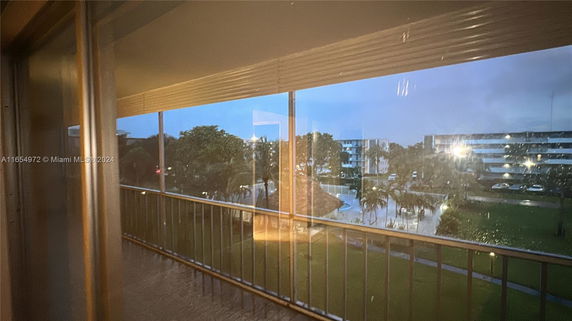 View from a building looking out towards other structures and landscaped areas with trees and pathways.