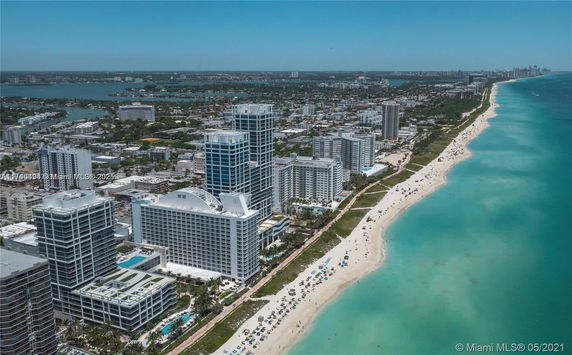Aerial view of coastal high-rise buildings adjacent to a beach.