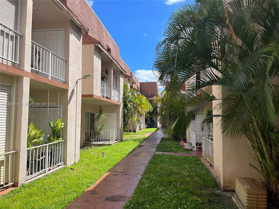 Outdoor view of a multi-story residential building with balconies and greenery.