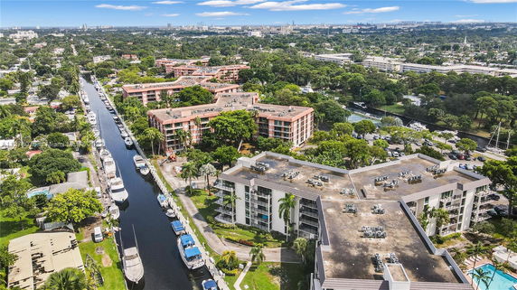 Aerial view of residential buildings and a canal with boats.