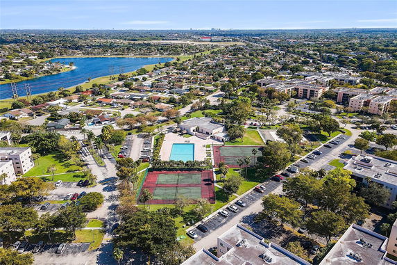Aerial view of a residential area with a swimming pool and sports courts.