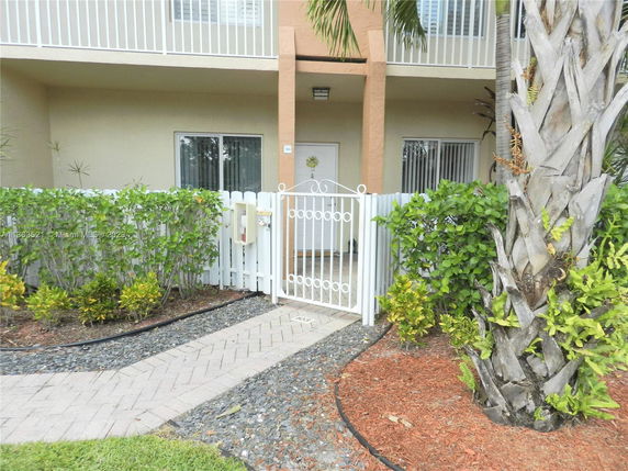 Front view of a two-story house with a gated entry and balcony.