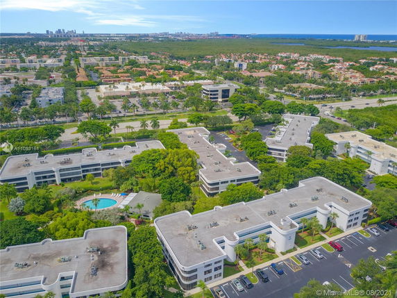 Aerial view of a residential area with multiple buildings and a swimming pool at the center.