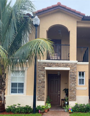 Front view of a two-story house with stone accents and an archway.