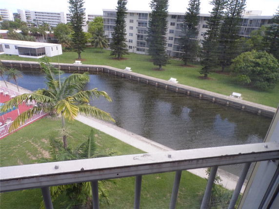 View of surrounding areas seen from a building, including a canal, trees, and other buildings.